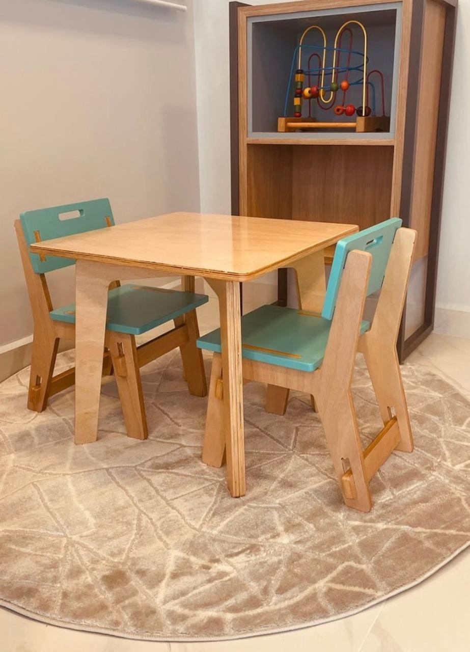 Mesa e cadeiras infantis do consultório, com brinquedos ao fundo